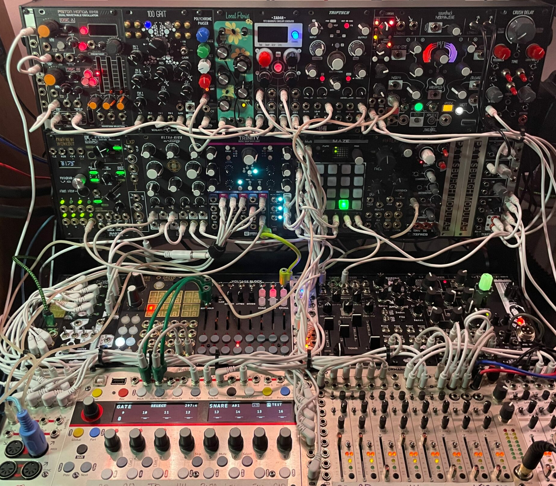 Densely patched Eurorack modular synth system with drum, oscillator, sequencer, and mixer modules.